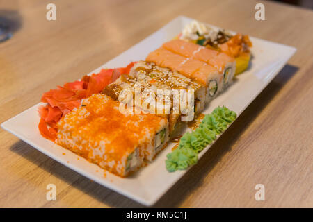 Frisches und Köstliches Sushi auf hölzernen Tisch. Stockfoto