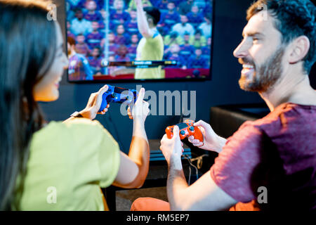 Junge aufgeregt paar Fußball spielen Spiel mit Spielkonsole sitzen auf der Couch am Spielen Club Stockfoto