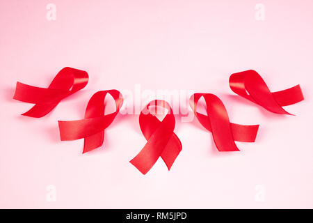 Aids-Aufklärung Zeichen rote Bänder auf rosa Hintergrund. Welt-AIDS-Tag Konzept. Die Gesundheit, Hilfe, Pflege, Support, Hoffnung, Krankheit, Gesundheitswesen Konzept Stockfoto