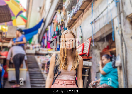 Frau Reisenden wählen Sie Souvenirs in den Markt in Ubud auf Bali, Indonesien Stockfoto