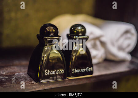 Nahaufnahme auf den Flaschen mit Shampoo, Duschgel und Handtücher im Hotel Bad Stockfoto