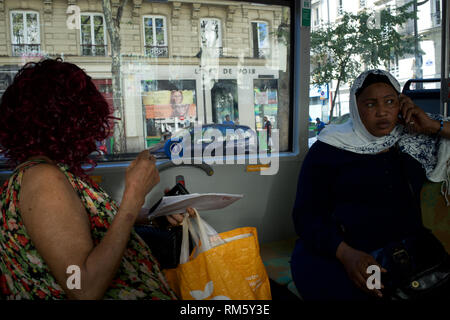 Headscarved schwarze afrikanische Frau. Frauen auf Reisen im Bus, Fenster und Blick auf den Boulevard Barbès, 75009 Paris, Frankreich Stockfoto