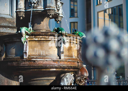 Nahaufnahme der grüne Eidechsen und Zwerg Kopf auf der Cholerabrunnen in Dresden, Deutschland. Vintage Blick auf den Brunnen mit fließendem Wasser an einem Frühlingstag Stockfoto