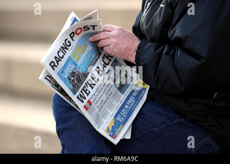 Eine racegoer liest die Racing Post mit der vorderen Seite Schlagzeile "Wir sind zurück", während der verletzte Jockeys Fonds Nächstenliebe Raceday at Plumpton Racecourse. Stockfoto