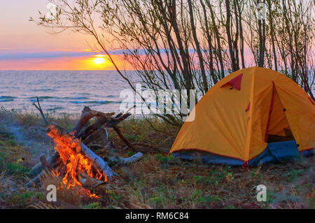 Zelt und Feuer am Strand, gelbe Zelt auf dem Sand Stockfoto