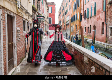 Zwei Posers gehen neben einem Kanal in Venedig. Sie sind Teilnehmer der Italienischen Karneval in Venedig. Stockfoto