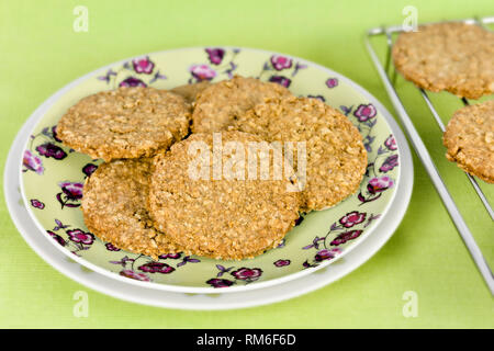 Frisch gebackene Hausgemachte verdauungsfördernden Plätzchen auf Teller vor einem grünen Hintergrund Stockfoto