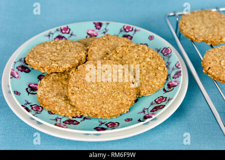 Frisch gebackene Hausgemachte digestive Biscuits auf Platte gegen einen blauen Hintergrund Stockfoto