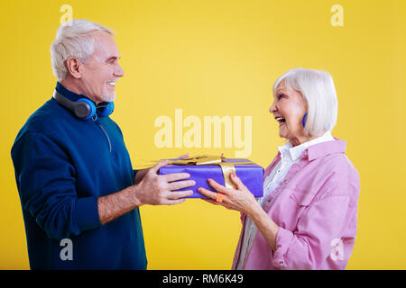 Pensionierte Dame Gefühl dankbar empfangen vorhanden, vom Ehemann Stockfoto