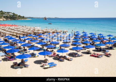 Ein Strand mit der Blauen Regenschirme - unscharfes Bild Stockfoto
