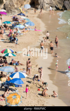 Ein Strand mit den bunten Sonnenschirmen - unscharfes Bild Stockfoto