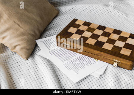 Holz- Schachbrett in der Nähe der Zeitung auf dem Sofa Stockfoto