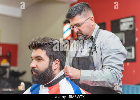 Gut aussehender bärtiger Mann, Haarschnitt, Friseur beim Friseur. Stockfoto