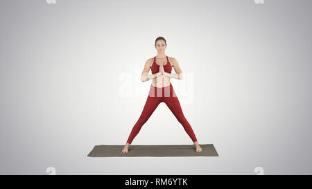 Junge Frau Üben Yoga, Oberflächen, Utthita parsvakonasana Übung auf farbverlauf Hintergrund. Stockfoto