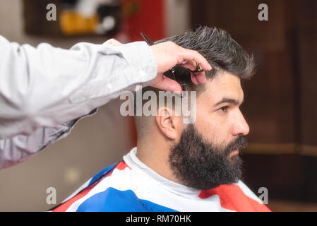 Gut aussehender bärtiger Mann, Haar, indem Sie die Schere an Friseur schneiden. Stockfoto