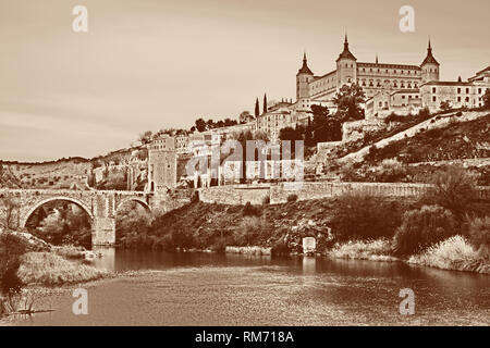Toledo mit Festung Alcazar, die Brücke und den Fluss Tajo de Alcantara, Spanien Stockfoto