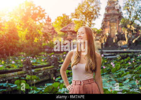 Junge Frau Reisenden im Hintergrund der Pura Taman Saraswati Kemuda Tempel in Ubud, Bali, Indonesien mit Sonnenlicht Stockfoto