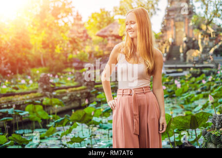 Junge Frau Reisenden im Hintergrund der Pura Taman Saraswati Kemuda Tempel in Ubud, Bali, Indonesien mit Sonnenlicht Stockfoto