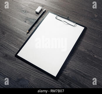 Zwischenablage mit leeren Briefbögen, Bleistift und Radiergummi auf Holz Tisch Hintergrund. Branding Schreibwaren mock up. Stockfoto