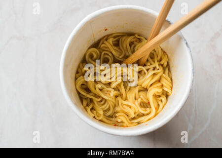 Instant Curry gewürzt, Ramen Nudeln serviert mit Stäbchen. in Plastikbecher. Traditionelle Fast Food. Stockfoto