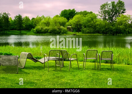 Liegen am Ufer des Teiches. Camping mit Stühlen Stockfoto