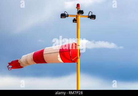 Horizontal fliegen Windsack Windfahne mit roten und weißen Linien gegen den blauen Himmel Stockfoto