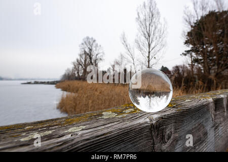 Glas Kugel liegen auf einem holzgeländer in der Nähe eines zugefrorenen See (Wien, Österreich) Stockfoto