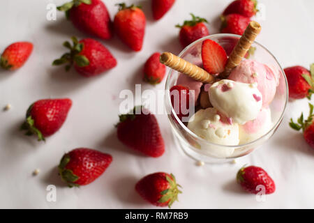 Eine Tasse Eis mit Erdbeeren und rollte Wafer. eis Nahaufnahme. Stockfoto