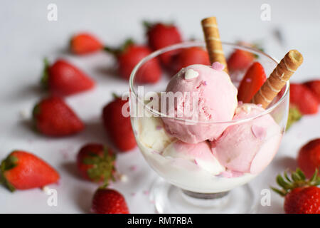 Eine Tasse Eis mit Erdbeeren und rollte Wafer. eis Nahaufnahme. Stockfoto