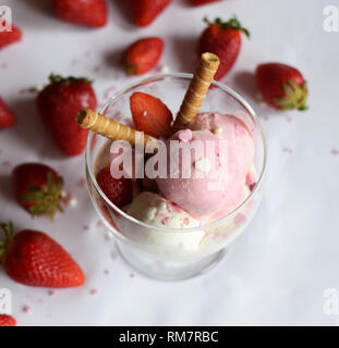 Eine Tasse Eis mit Erdbeeren und rollte Wafer. eis Nahaufnahme. Stockfoto