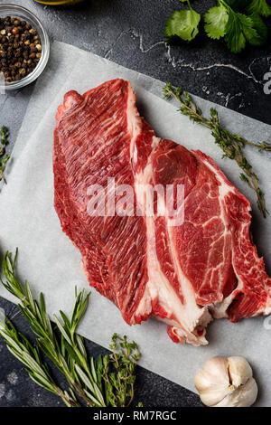 Close up Stück Rindfleisch an Handwerk Papier mit Thymian und Rosmarin. Makro. Konzept von Frische, gesunde Lebensmittel Stockfoto