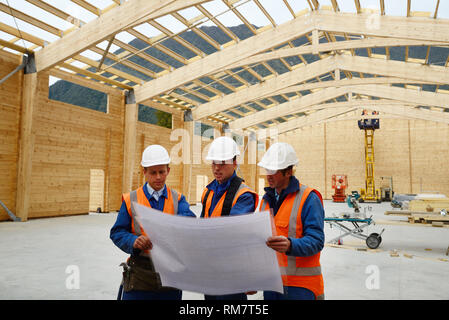 Drei Bauherren diskutieren den Plan für einen großen Bau job Stockfoto