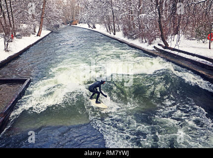 München, Surfer, die künstliche Welle am Eisbach, kleinen Fluss über den Englischen Garten, in einem eiskalten Februar morgen Stockfoto