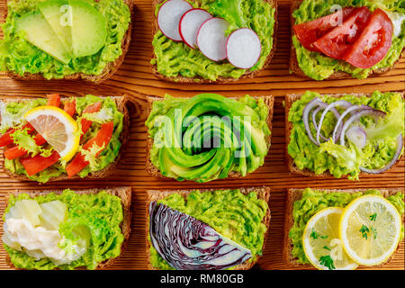 Frische, gesunde vegetarische Frühstück mit Vollkorn Sandwiches, Avocado Toast mit verschiedenen Belägen Stockfoto