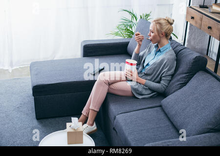 Verärgert Frau Eis essen während siitng auf der Couch zu Hause alleine Stockfoto