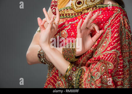 7/8-Ansicht der indischen Frau in traditioneller Kleidung mit Gyan mudra, isoliert auf Grau Stockfoto