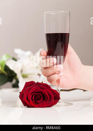 Schöne Frau hand mit polierten Nais holding Glas Rotwein Stockfoto
