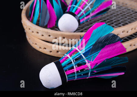Bunte Federn im Badminton Federball. Mannschaft spielen. Der dunkle Hintergrund. Stockfoto
