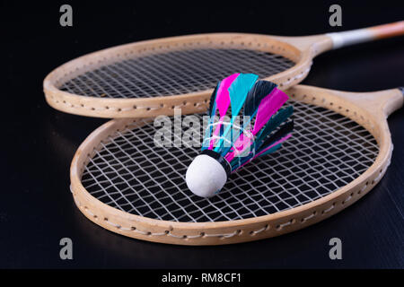 Bunte Federn im Badminton Federball. Mannschaft spielen. Der dunkle Hintergrund. Stockfoto