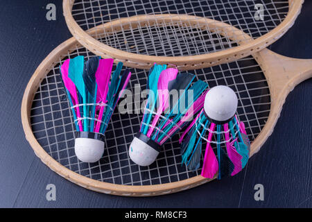 Bunte Federn im Badminton Federball. Mannschaft spielen. Der dunkle Hintergrund. Stockfoto