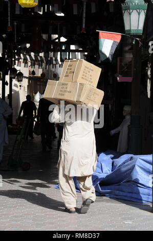 Eine asiatische Lieferung Fahrer waren, die auf seiner Schulter in den Gold Souk im Stadtteil Deira in Dubai in den Vereinigten Arabischen Emiraten (VAE) Stockfoto