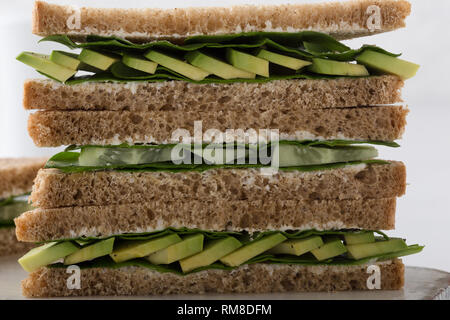 Gesund vegan Sandwiches mit grünem Gemüse und Grüns. Avocado, Spinat und Gurke Toast auf Schneiden boardover weißen Hintergrund. Auf pflanzlicher Basis fo Stockfoto