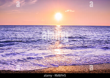 Lila Landschaft mit Blick auf das Meer und den Sonnenuntergang. Abendsonne über Meer. schöne Landschaft mit Sonnenaufgang über dem See Panoramaaussicht Stockfoto