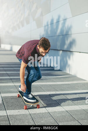 Hipster Mann, longboard Stockfoto