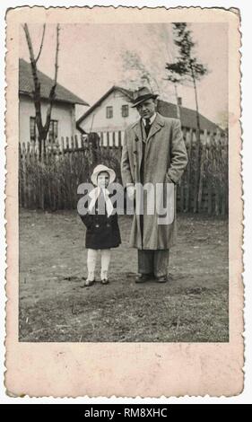 Retro-Foto zeigt Vater und kleine Tochter gehen für einen Spaziergang. Vater und kleines Mädchen entspannen und genießen Zeit im Freien. Schwarz-weißer Jahrgang.60s. Stockfoto