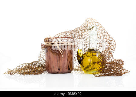 Handgefertigte Sardellen Filets in Olivenöl in einer transparenten Glas Glas. Volle Glas salzige Sardellen Filets auf weißem Hintergrund, aus der Nähe. Stockfoto