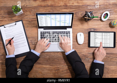 Ansicht von oben von einem Geschäftsmann zu tun Multitasking auf elektronische Geräte Stockfoto