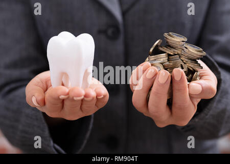Die junge Frau Hand mit weißen Zähnen und Münzen über Schreibtisch Stockfoto