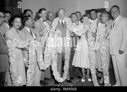 Präsident Dwight Eisenhower und die erste Dame Mamie sind in einem 150 Fuß langen Lei durch eine Delegation aus dem Gebiet von Hawaii präsentiert gewickelt, Ca. 1955. Stockfoto