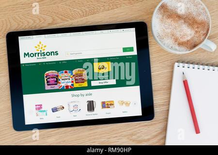 Die Morrisons website Funktionen auf einem iPad Tablet Gerät, das auf einem Tisch liegt neben einem Notizblock (nur redaktionelle Nutzung). Stockfoto